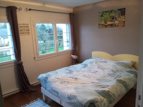 una camera da letto con un letto e due finestre di maison des papillons a Tourville-la-Chapelle