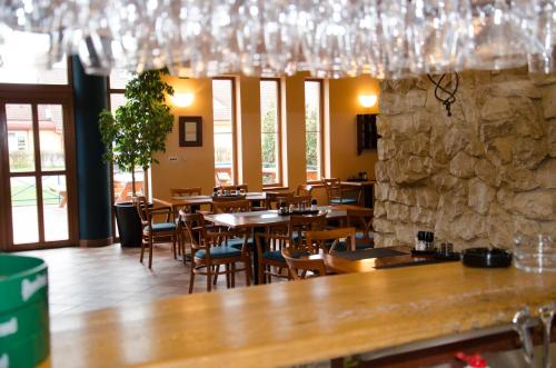 a restaurant with tables and chairs and a stone wall at Hotel U Milína in Milín