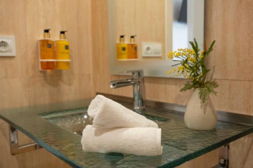 Hotel Siuranella في سويرانا: منضدة الحمام مع حوض مع منشفة