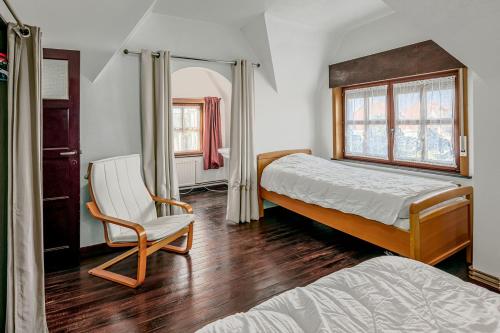 um quarto com 2 camas e uma cadeira em Lucky em Sint-Idesbald