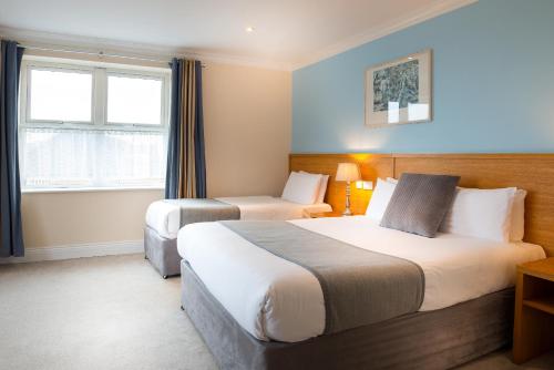 a hotel room with two beds and a window at Hotel Ceann Sibeal in Dingle