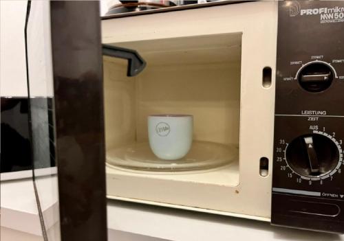 a microwave with a cup inside of it at Wohnung für 1-2 Personen - Zu Fuß zur Messe - mit U-Bahn in die City in Nuremberg