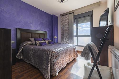 Dormitorio púrpura con cama y ventana en Parque Norte, en Cabezo de Torres