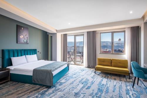 a hotel room with a bed and a chair at Hotel Address 9D in Tbilisi City