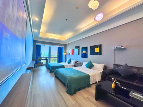a hotel room with two beds and a couch at Guangzhou Xing Yi International Apartment Hotel - Vertical City Branch in Guangzhou