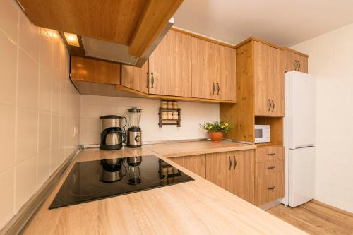 a kitchen with wooden cabinets and a coffee maker on the counter at El Paseo del Faro in Chipiona