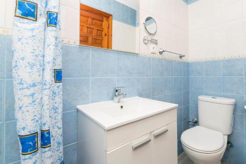 a bathroom with a toilet and a sink and a mirror at El Paseo del Faro in Chipiona
