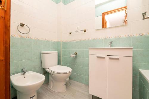 a bathroom with a toilet and a sink at El Paseo del Faro in Chipiona