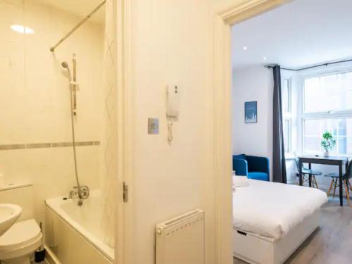 a bathroom with a toilet and a sink and a bed at Pass the Keys Kings Cross Urban Escape in London