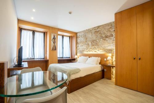 une chambre d'hôtel avec un lit et une table en verre dans l'établissement Reis de Gaia, à Vila Nova de Gaia
