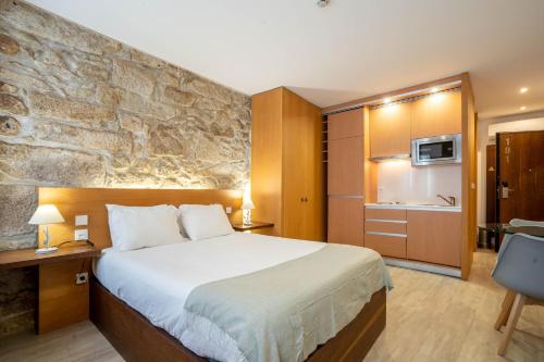 a hotel room with a bed and a stone wall at Reis de Gaia in Vila Nova de Gaia