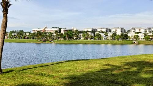 a lake in a park with buildings in the background at Cozy Apartment Asatti Agate Yellow Vanya Park in Pagedangan