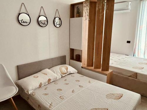 a bedroom with two beds and two clocks on the wall at Foleza Studio Apartament-Shengjin in Margjonaj