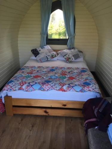 a bed in a small room with a window at Belle Vista Glamping & Camping in York