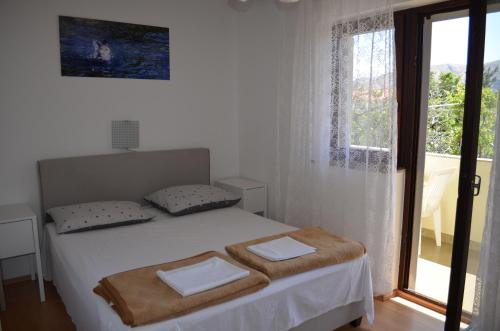 una camera da letto con un letto e una finestra con vista di Apartments Aneva 1 a Baška