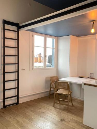 une cuisine avec une table et une chaise ainsi qu'une fenêtre dans l'établissement Résidor - Sublime appartement à Porte Dauphine, à Paris