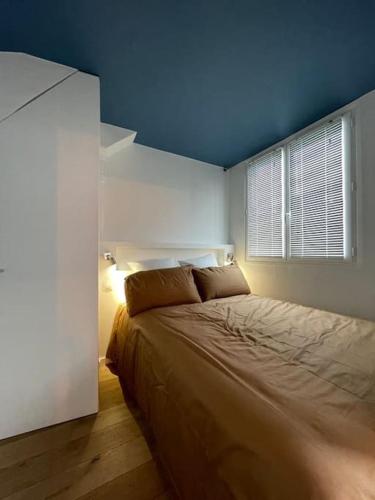 une chambre avec un lit avec un plafond bleu dans l'établissement Résidor - Sublime appartement à Porte Dauphine, à Paris