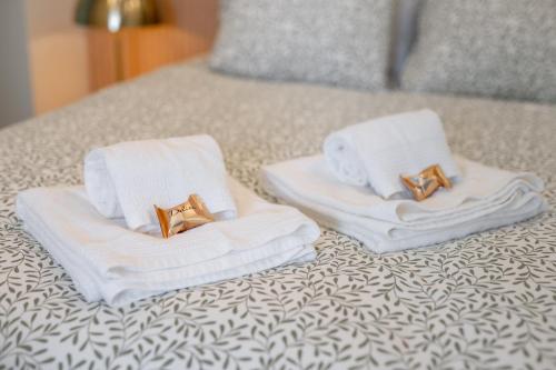 two towels with gold rings on them on a bed at MAM HEAT River Nest - Darque Village Centre in Viana do Castelo