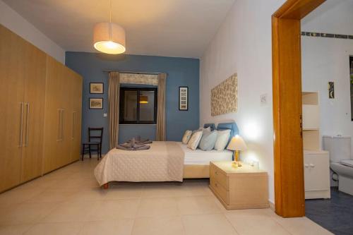 ein Schlafzimmer mit einem Bett und einer blauen Wand in der Unterkunft Prime Located Home by *The Sea* in Sliema