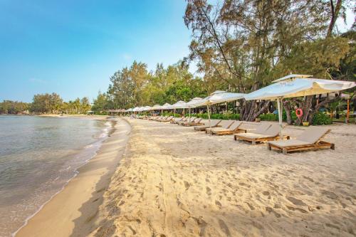 a row of chairs and umbrellas on a beach at Ocean Bay Phu Quoc Resort and Spa in Phu Quoc