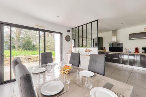 une cuisine et une salle à manger avec une table et des chaises dans l'établissement Maison pour 6 - Jardin - Proche plage, à Sarzeau