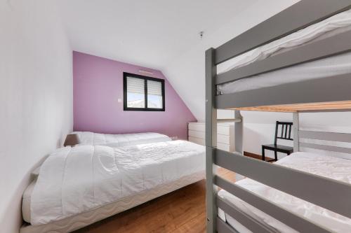 - une chambre avec 2 lits superposés et un mur violet dans l'établissement Maison pour 6 - Jardin - Proche plage, à Sarzeau