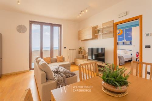 a living room with a dining table and a living room with the ocean at Wanderlust Experience Portsea Apartment in Giovinazzo