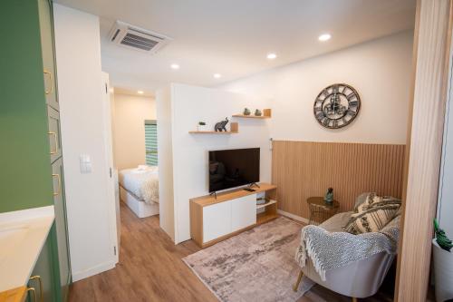 a living room with a couch and a clock on the wall at MAM HEAT River Nest - Darque Village Centre in Viana do Castelo