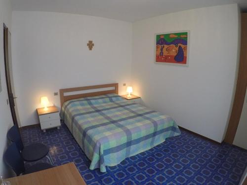 una camera con un letto e un tavolo e due luci di Condominio Commerciale a Caorle