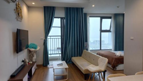 a hotel room with a bed and a couch and windows at The Wonder Bay Halong studio in Ha Long