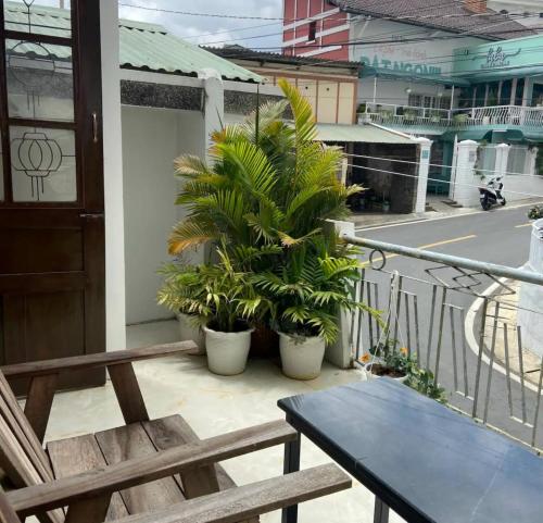 a balcony with a table and chairs and plants at Ame Soeur Đà Lạt in Da Lat