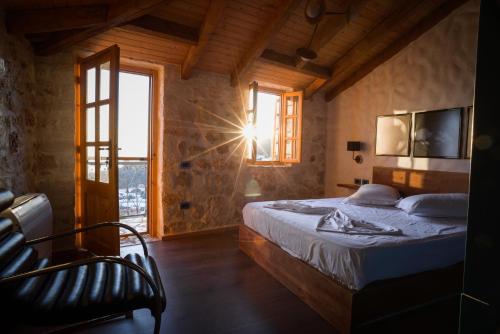 een slaapkamer met een bed en een raam bij Roots Dhermi in Dhërmi