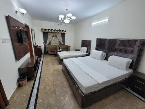 a bedroom with two beds and a television in it at Karachi Family Guest House in Karachi