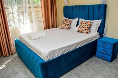 a blue bed in a room with a window at Lakeside Homes 1 in Kisumu