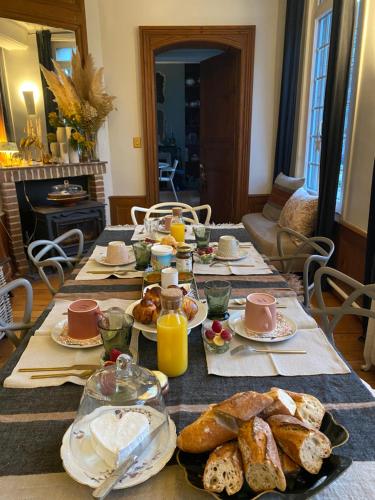 un tavolo con colazione a base di pane e succo d'arancia di La benjamine a Cany-Barville