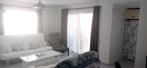 a white living room with a couch and a table at Ático en terrazas de Garrucha con vistas al mar. in Garrucha