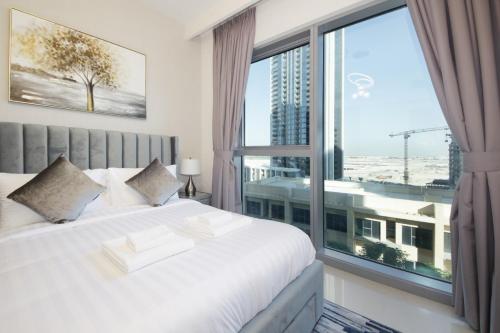 a bedroom with a large window with a view of a city at Elegant Waterfront 1BHK in Dubai Creek Harbour in Dubai