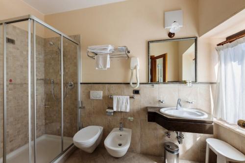 e bagno con servizi igienici, lavandino e doccia. di Hotel Miramonti Corvara a Corvara in Badia