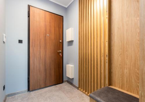 a closet with a wooden door in a room at Nadmotławie Chic Apartment in Gdańsk