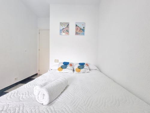 ein Schlafzimmer mit einem weißen Bett und Handtüchern darauf in der Unterkunft Avenida Principal con Wifi y Smart Tv - By Aloha Palma in Águilas