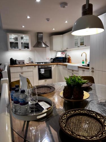 a kitchen with a table with water bottles on it at Olive Tree Apartment Hove in Brighton & Hove