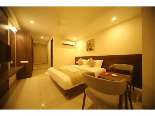 a hotel room with a bed and a table at Hotel Jayson Metoda in Rajkot