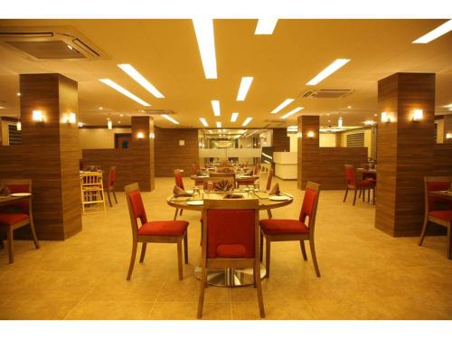 Hotel Jayson Metoda في راجكوت: مطعم فيه طاولات وكراسي في الغرفة
