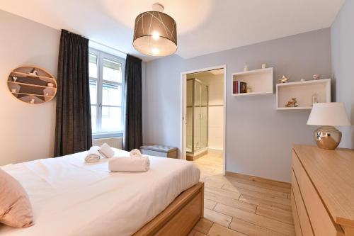 Un dormitorio con una gran cama blanca y una ventana en Appartement The Fairytale en Colmar