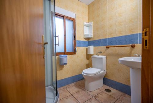 a bathroom with a toilet and a sink at Camping Rural Ria de Arosa 2 in Ribeira