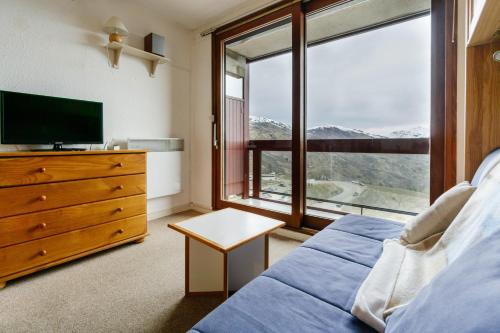 une chambre avec un lit et une grande fenêtre dans l'établissement Studio pied des pistes, à Villarembert