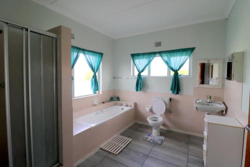 Un baño con bañera, inodoro y lavabo. en Heide 15, en Struisbaai