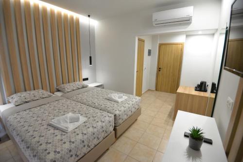 a small bedroom with two beds and a table at Heleni Beach Hotel in Ialyssos