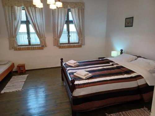 a bedroom with a large bed with three windows at Winaria in Erdut