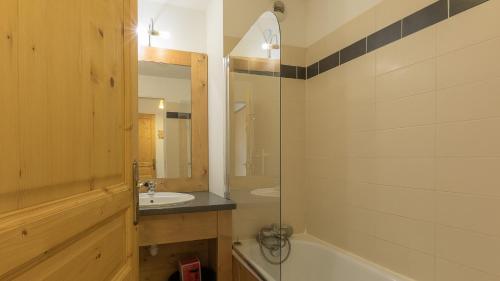 ein Bad mit einer Badewanne, einem Waschbecken und einer Dusche in der Unterkunft B203- Appartement 2 pieces cabine 6 personnes in Orcières